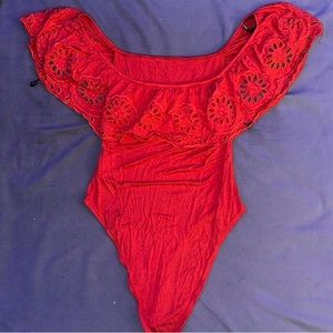 Red body suit with ruffles off the shoulders